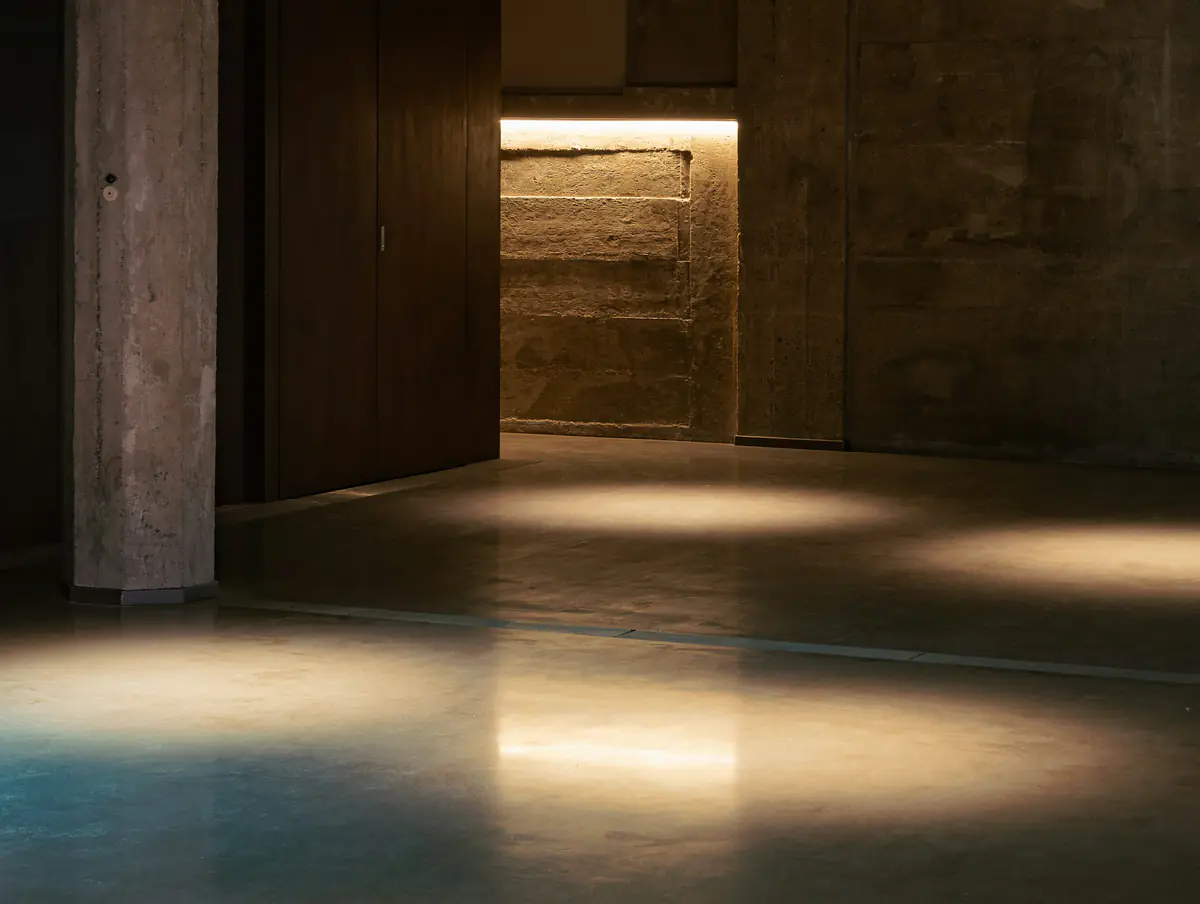 Daylight falling across a cast concrete interior with a polished floor